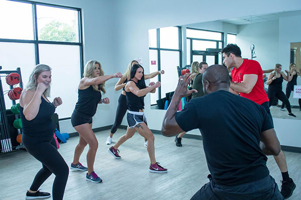 Cardio kickboxing class at Point Fitness Club Saskatoon with participants throwing punches and kicks Cardio kickboxing class at Point Fitness Club Saskatoon with participants throwing punches and kicks