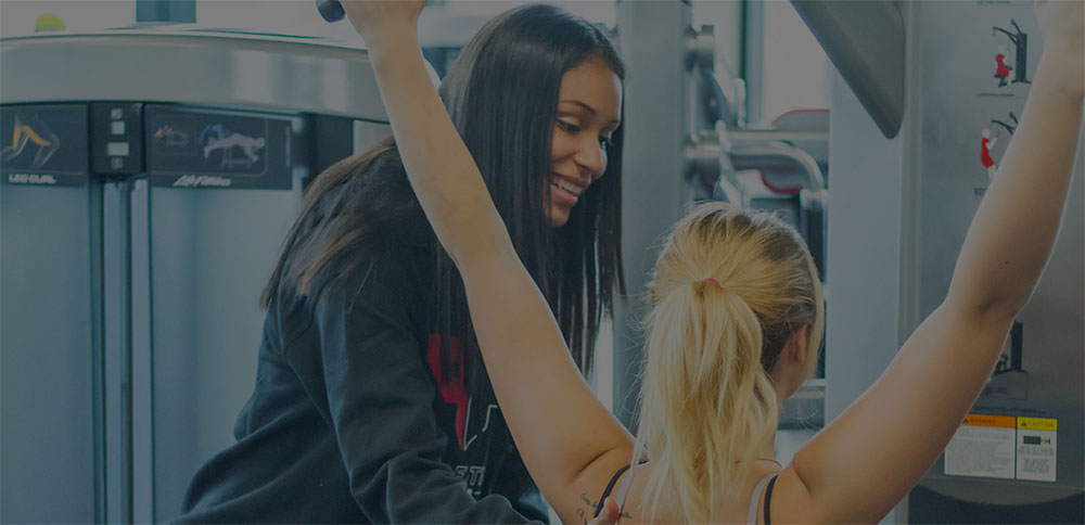 Certified personal trainer at Point Fitness Club Saskatoon working one-on-one with a client to develop a tailored fitness plan for optimal results.